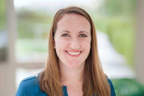 Headshot of woman in blue shirt and brown hair